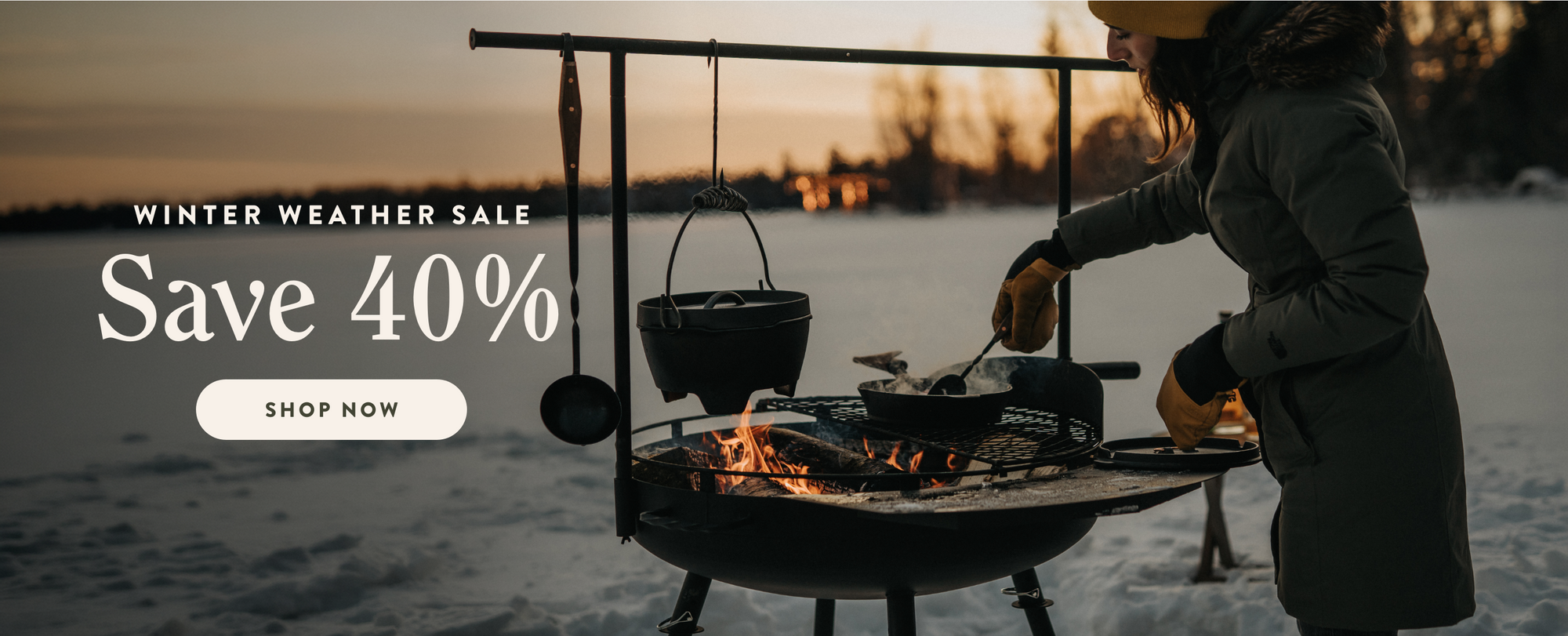 Person cooking over a Barebones Cowboy Grill in the snow with a winter weather sale banner overlay. Save 40%. Shop Now.