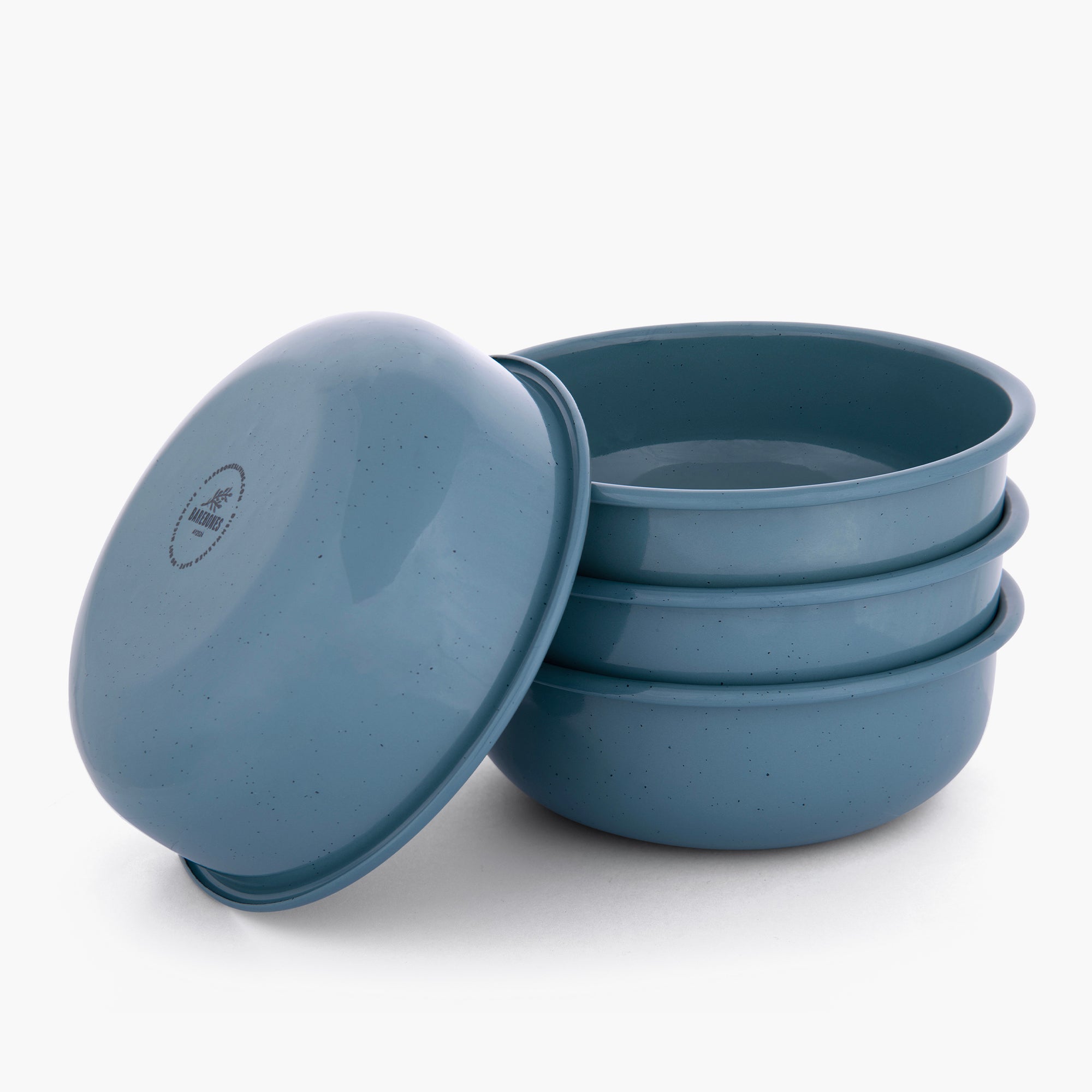 Set of four smoky blue rolled enamel bowls on a white background