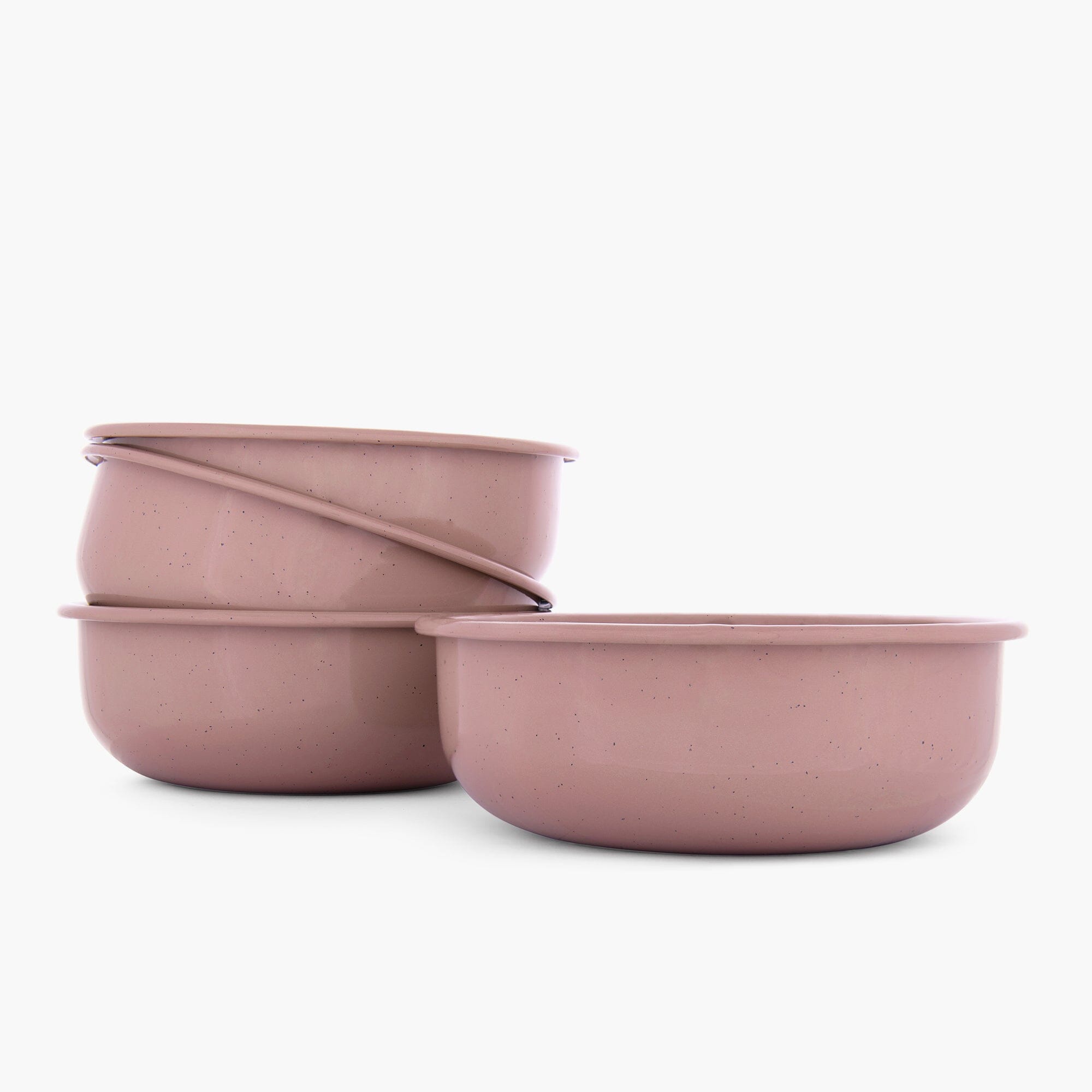 Set of four dusty rose rolled enamel bowls on a white background