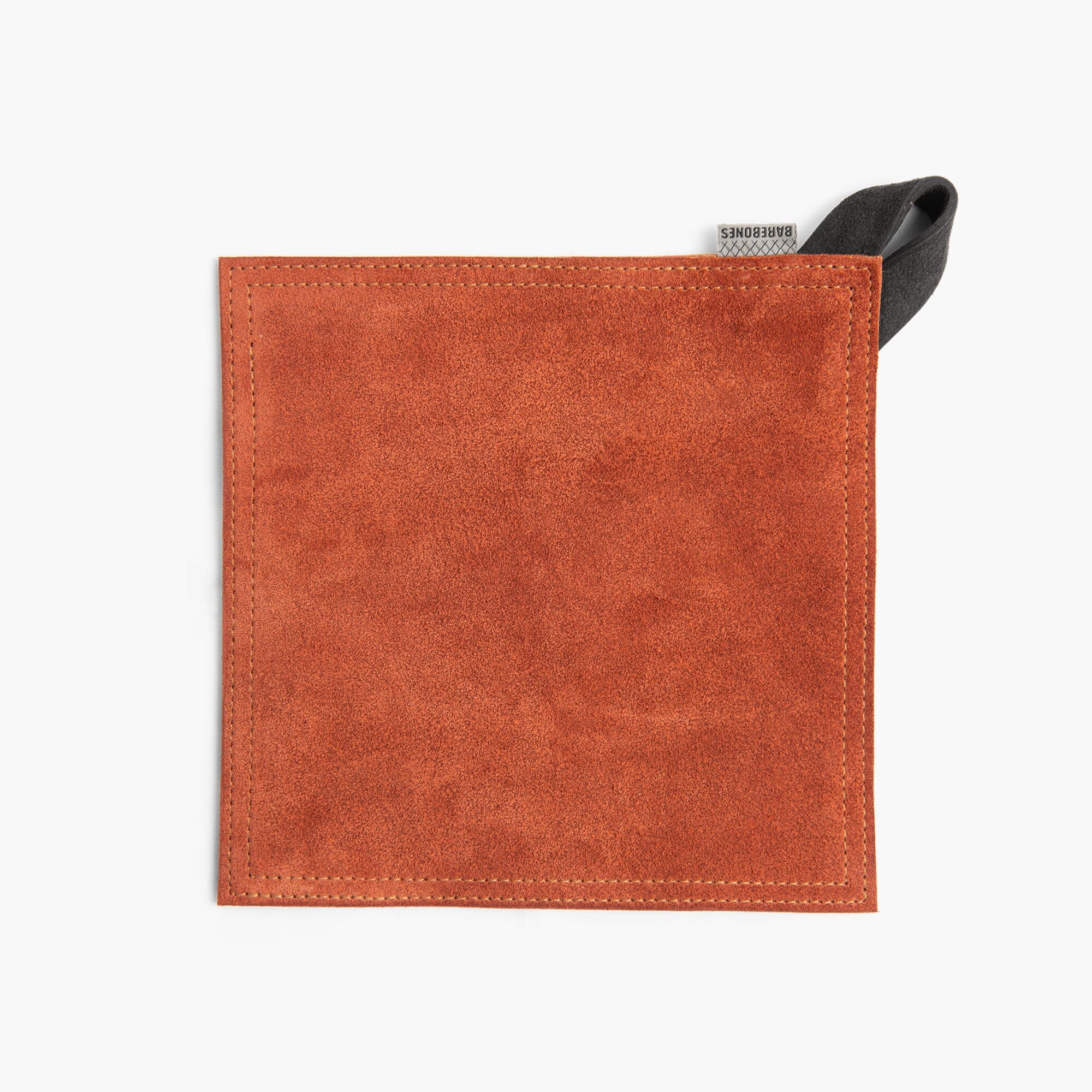 Terracotta suede leather hot pad with a black hanging strap on a white background